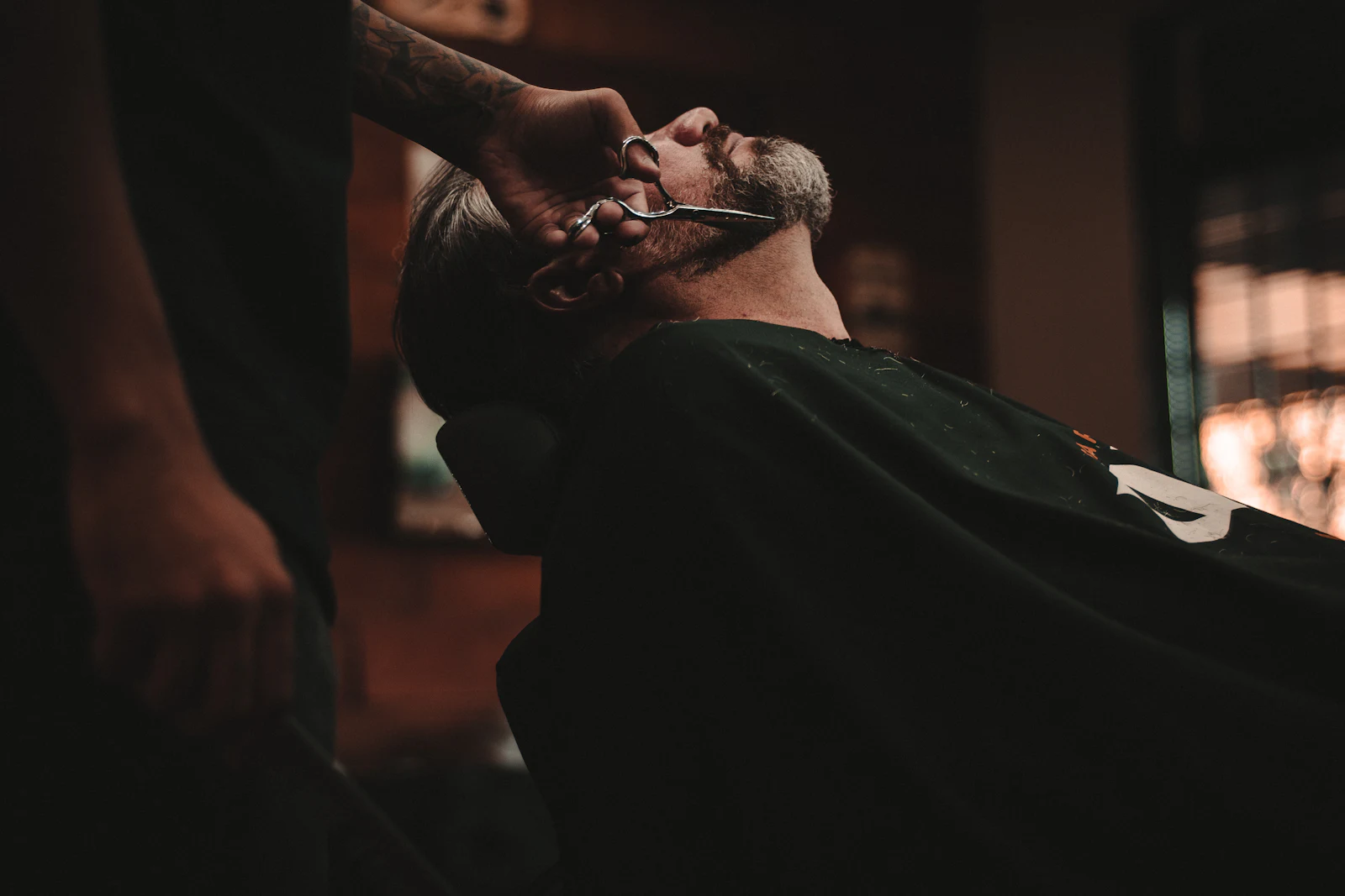 Un barbier rase un client au rasoir