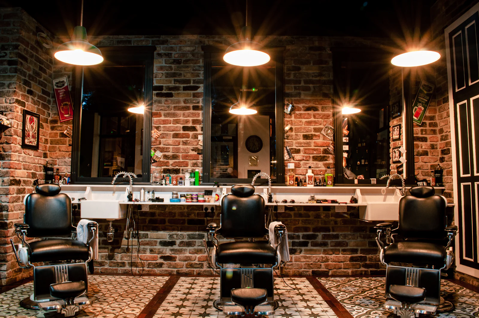 Un barbershop avec fauteuils en cuir et murs de briques