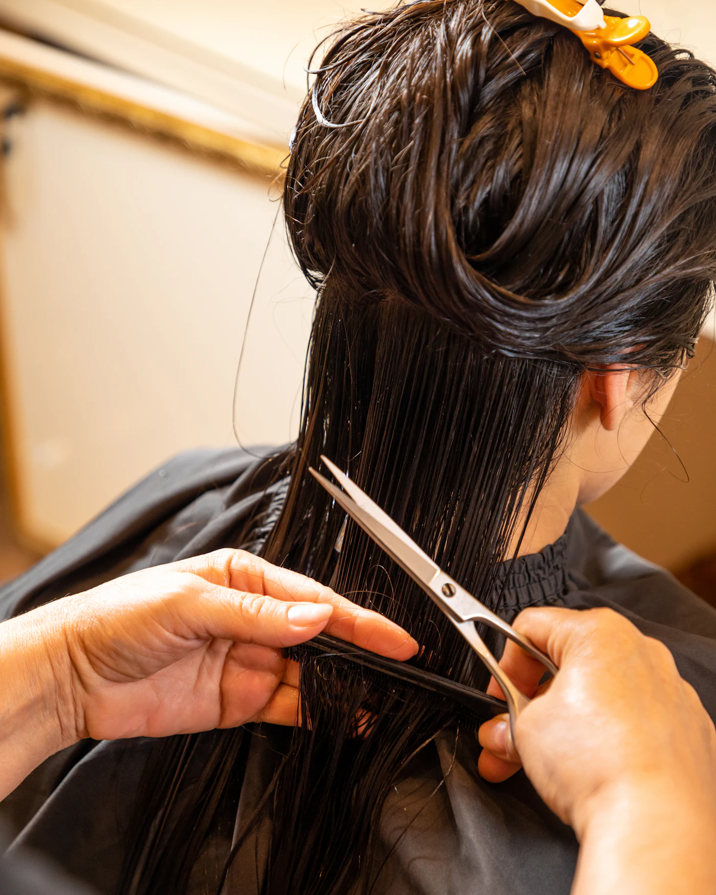 Une coiffeuse coupe des cheveux mouillés