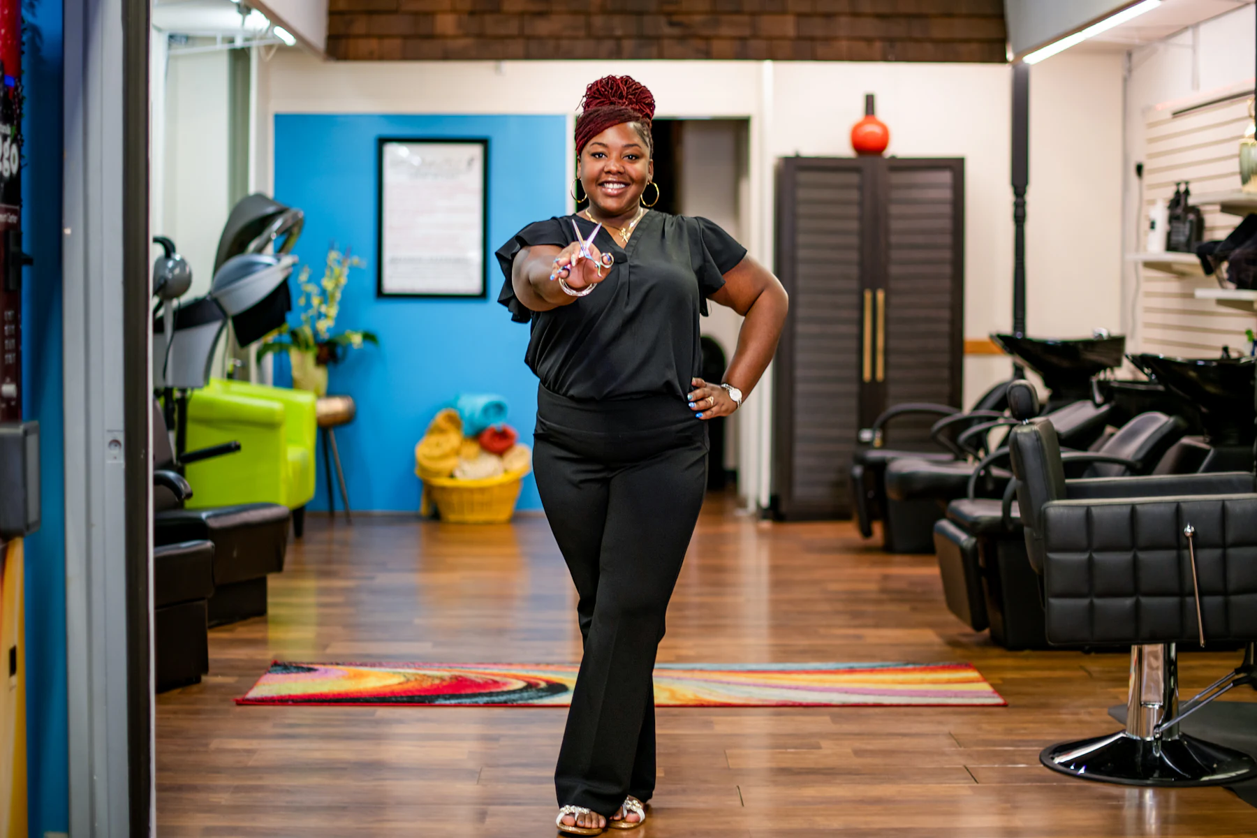Une coiffeuse dans son salon, ciseaux à la main