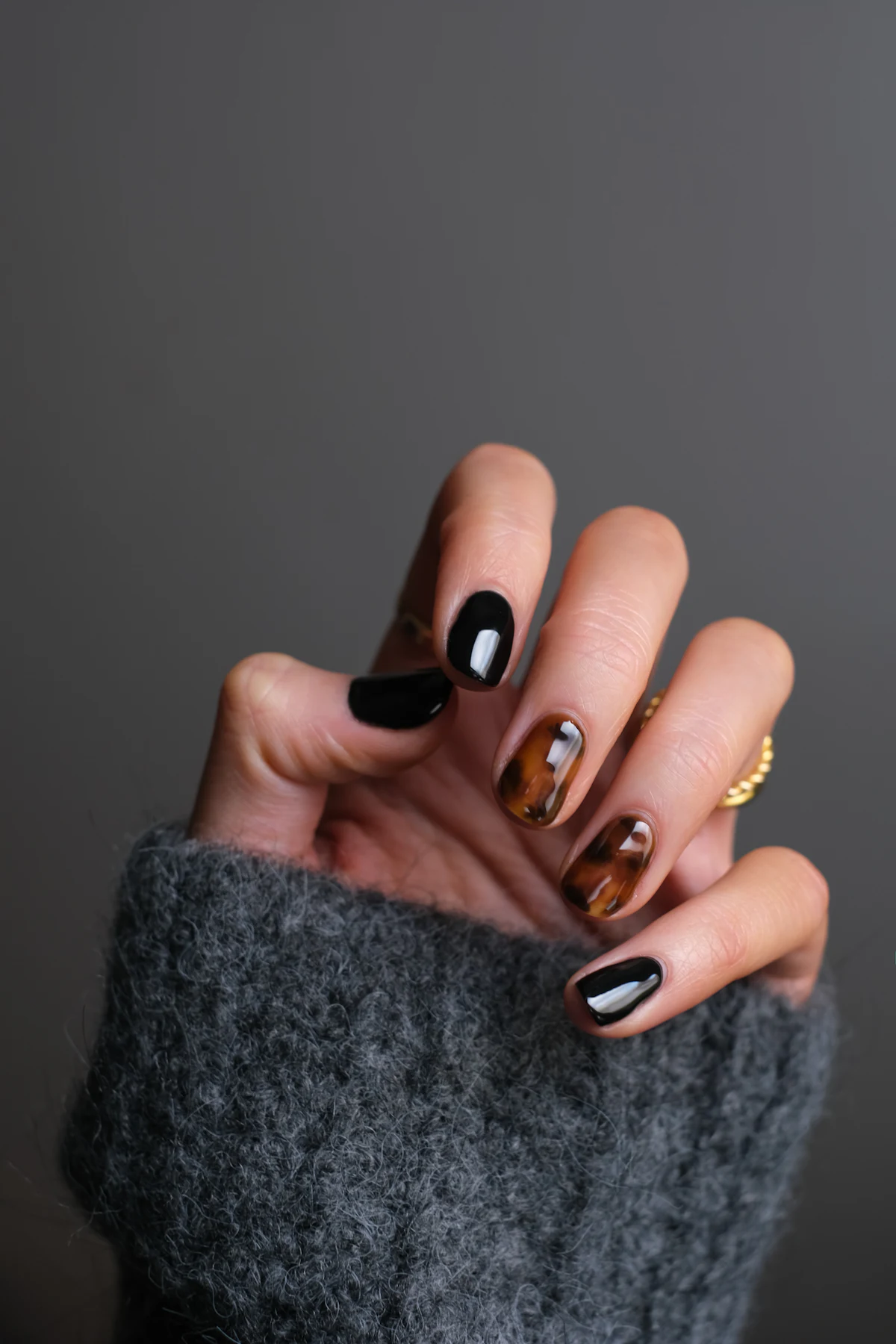 Une main aux ongles vernis noirs