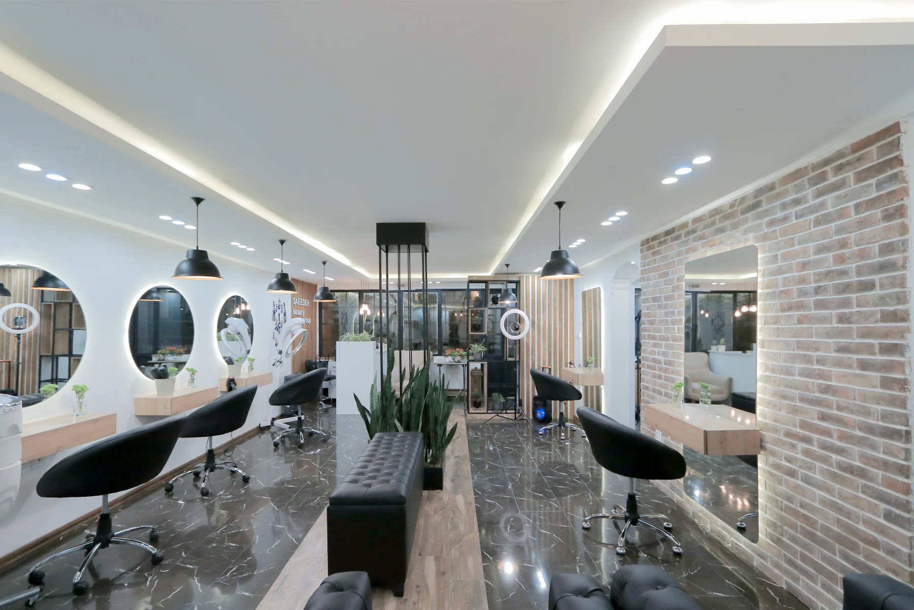 Un salon de coiffure moderne, fauteuils noirs et miroirs ronds